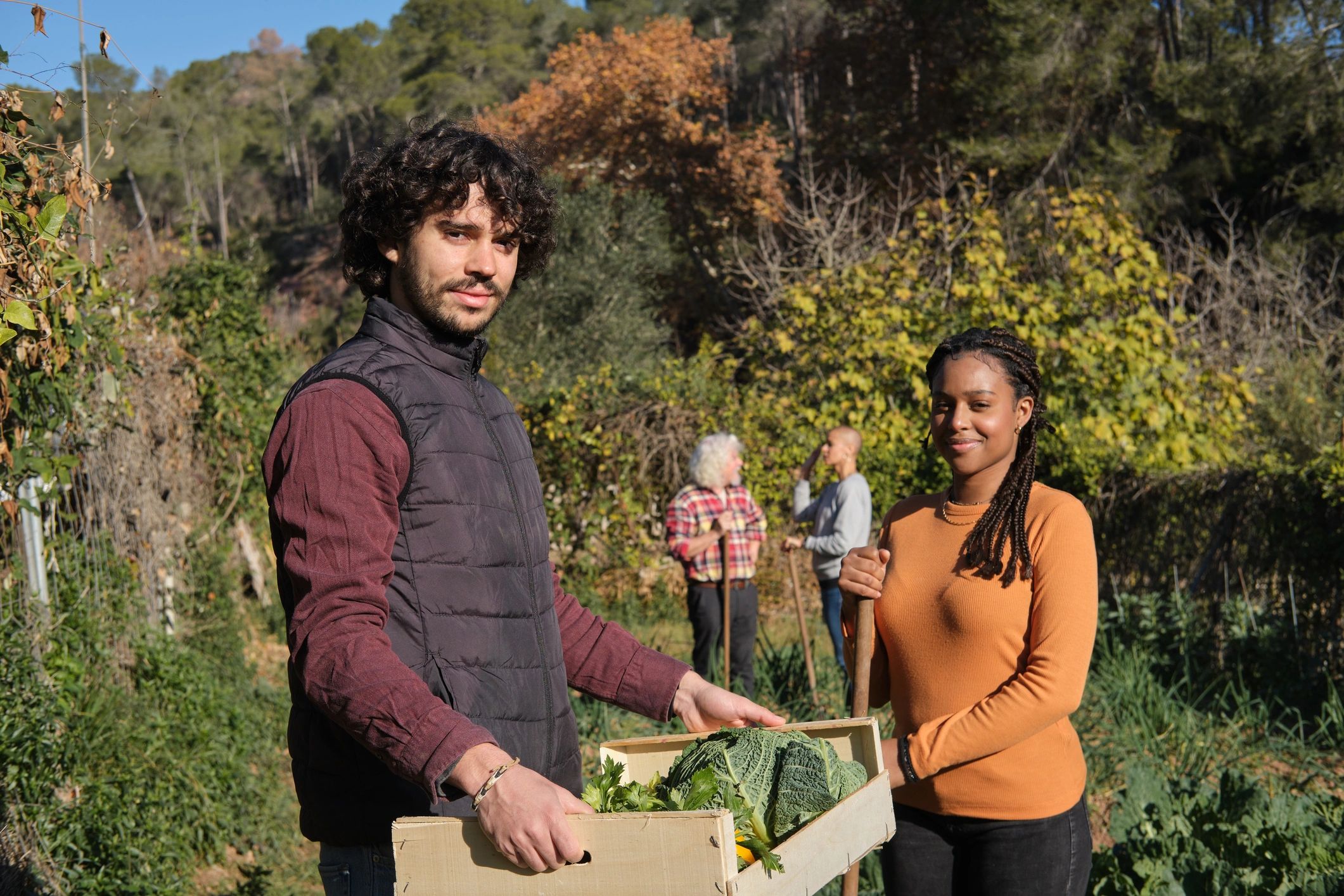 Two agricultural workers smiling together in a garden